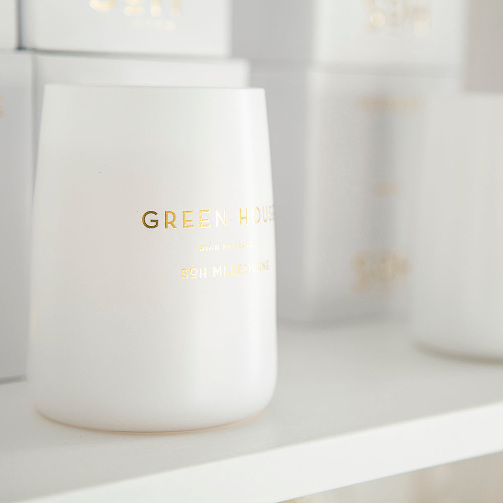 SoH green house candle on shelf.