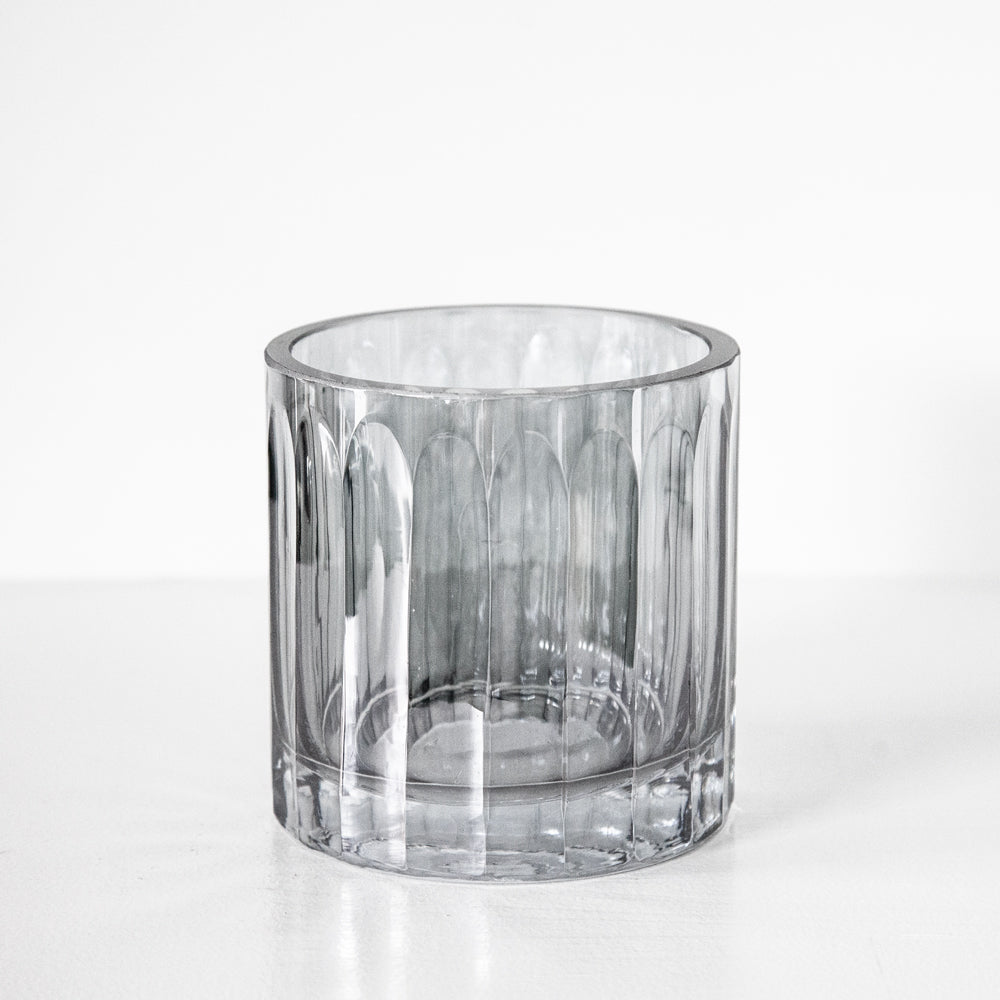 Small dark tinted glass vase with ridged design.