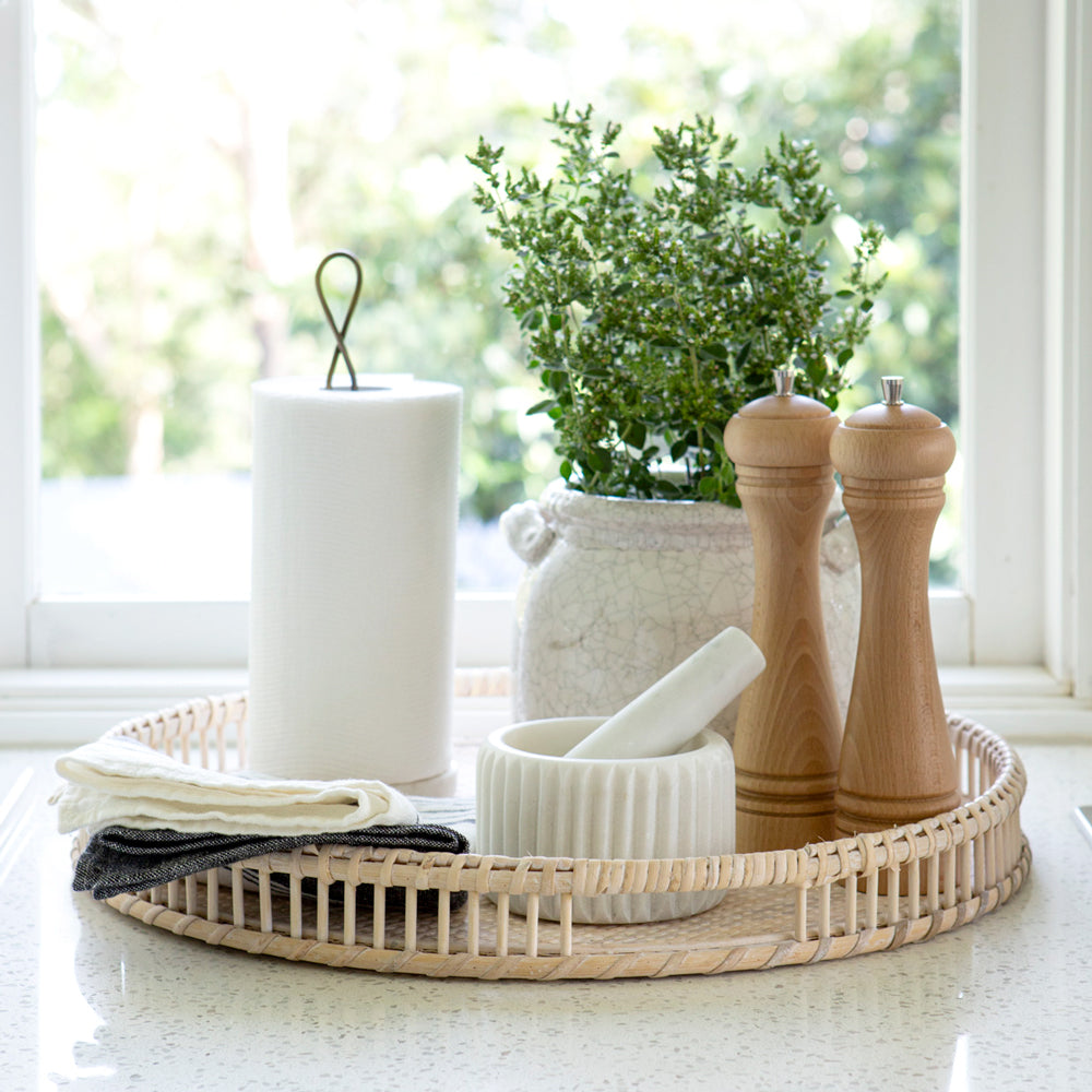 Paper towel holder on rattan tray in kitchen.