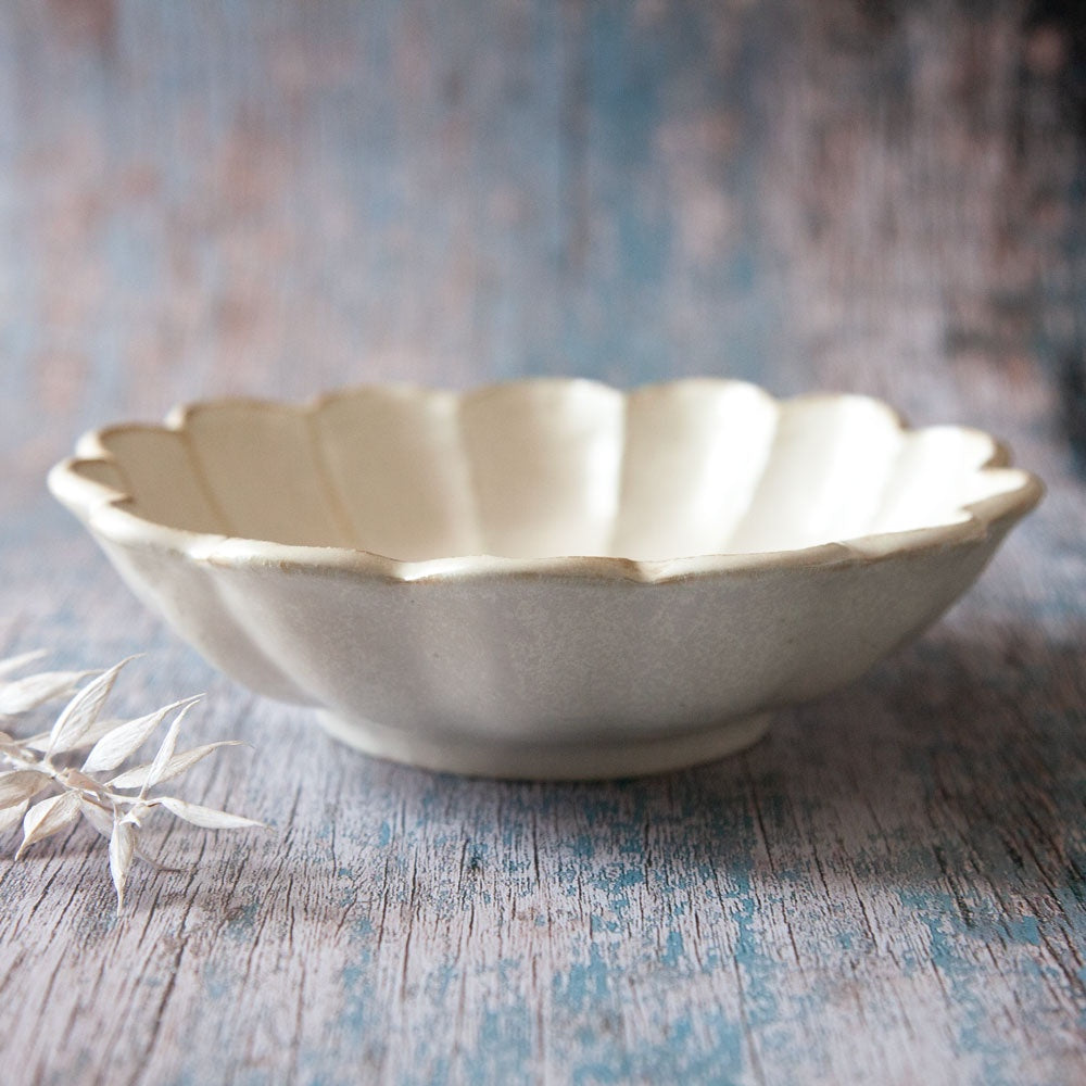 Rinka ceramic bowl featuring scalloped edged design resembling a flower.