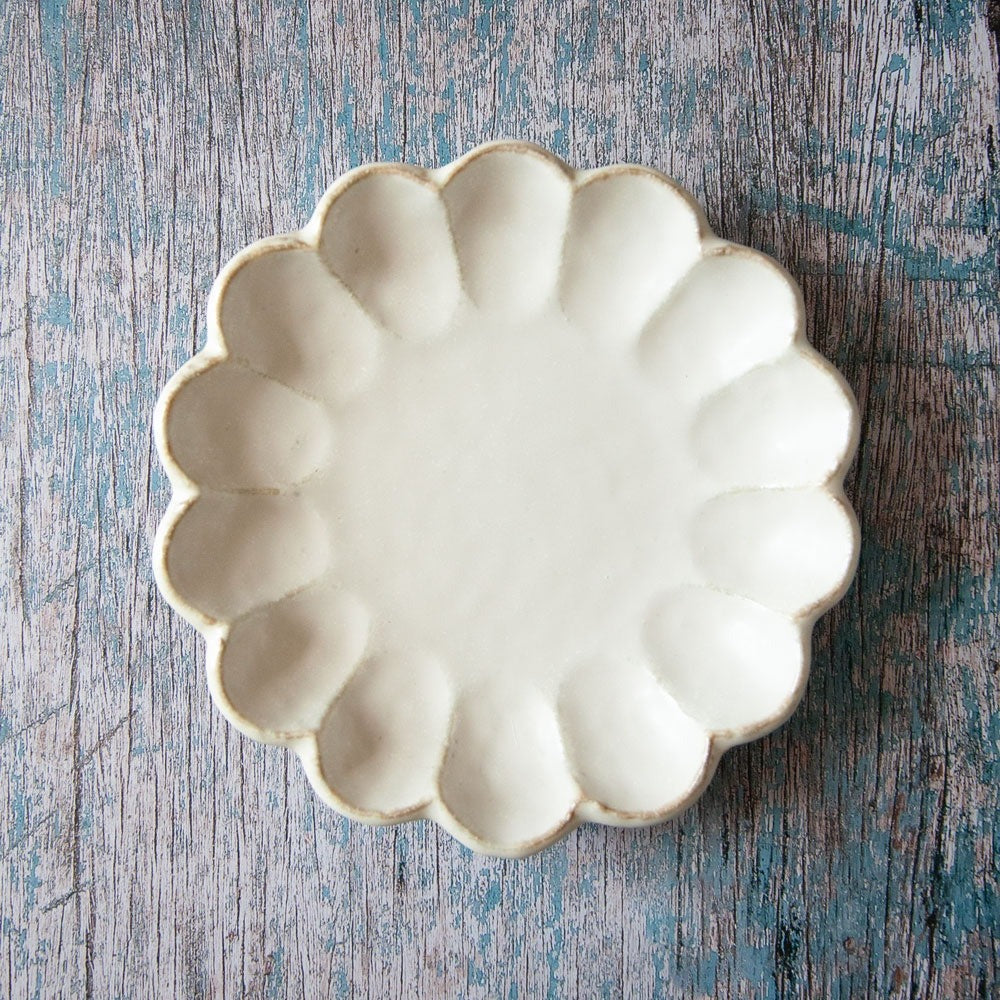 Rinka ceramic plate featuring scalloped edged design resembling a flower.