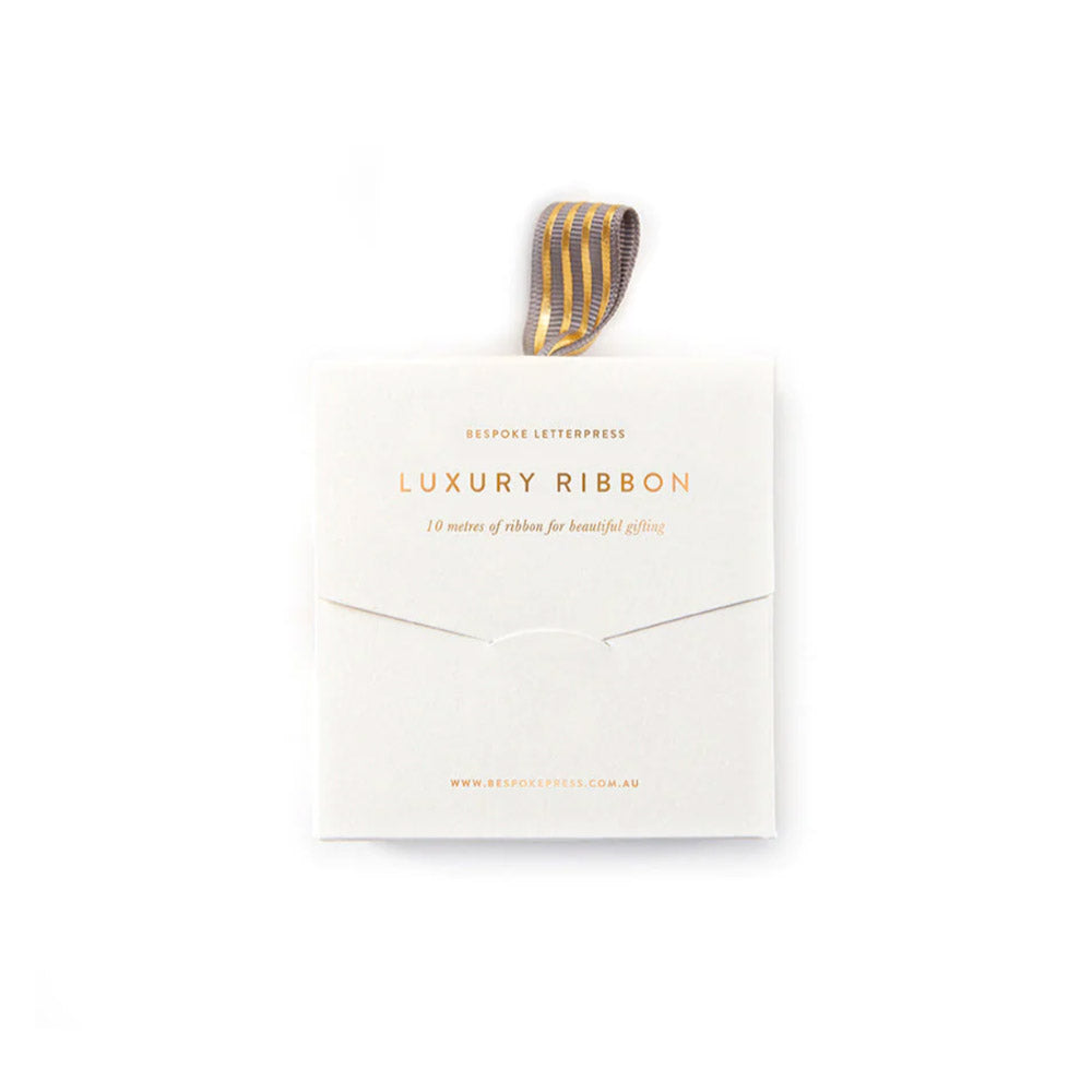 Grey grosgrain ribbon with gold stripe in sleek cardboard box.