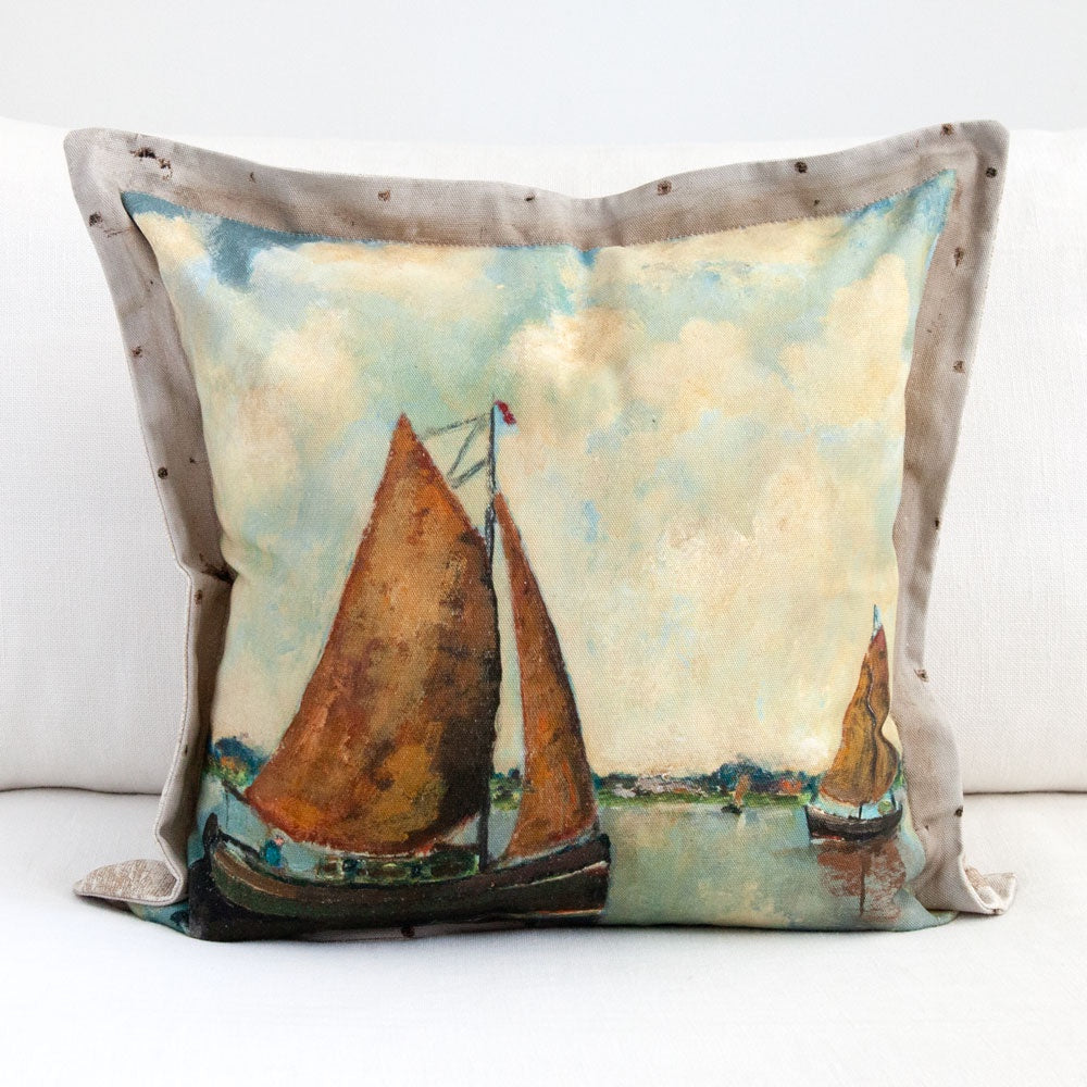 Cushion featuring painting of sail boats on a lake with big fluffy clouds in the sky.