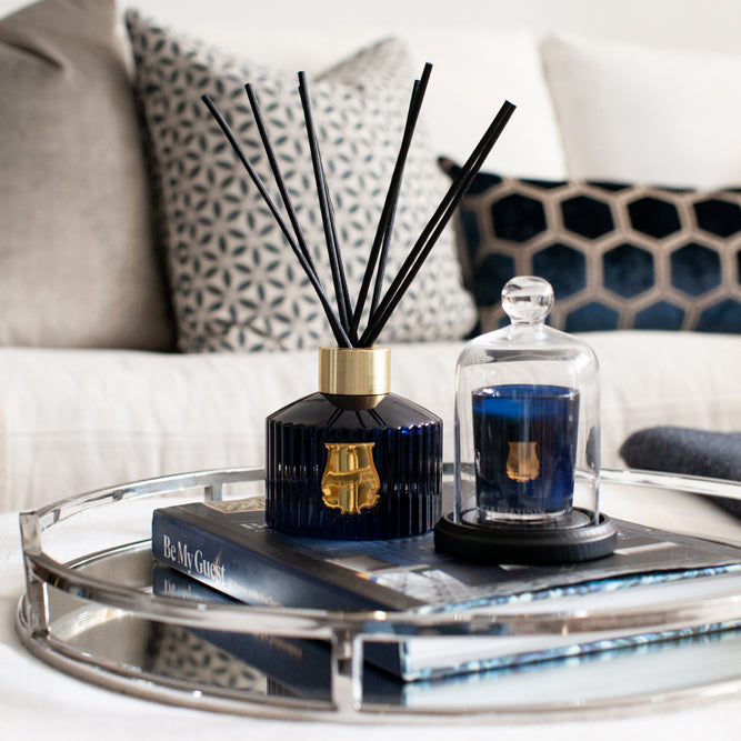 Trudon madurai blue glass diffuser displayed on mirror tray in living room.