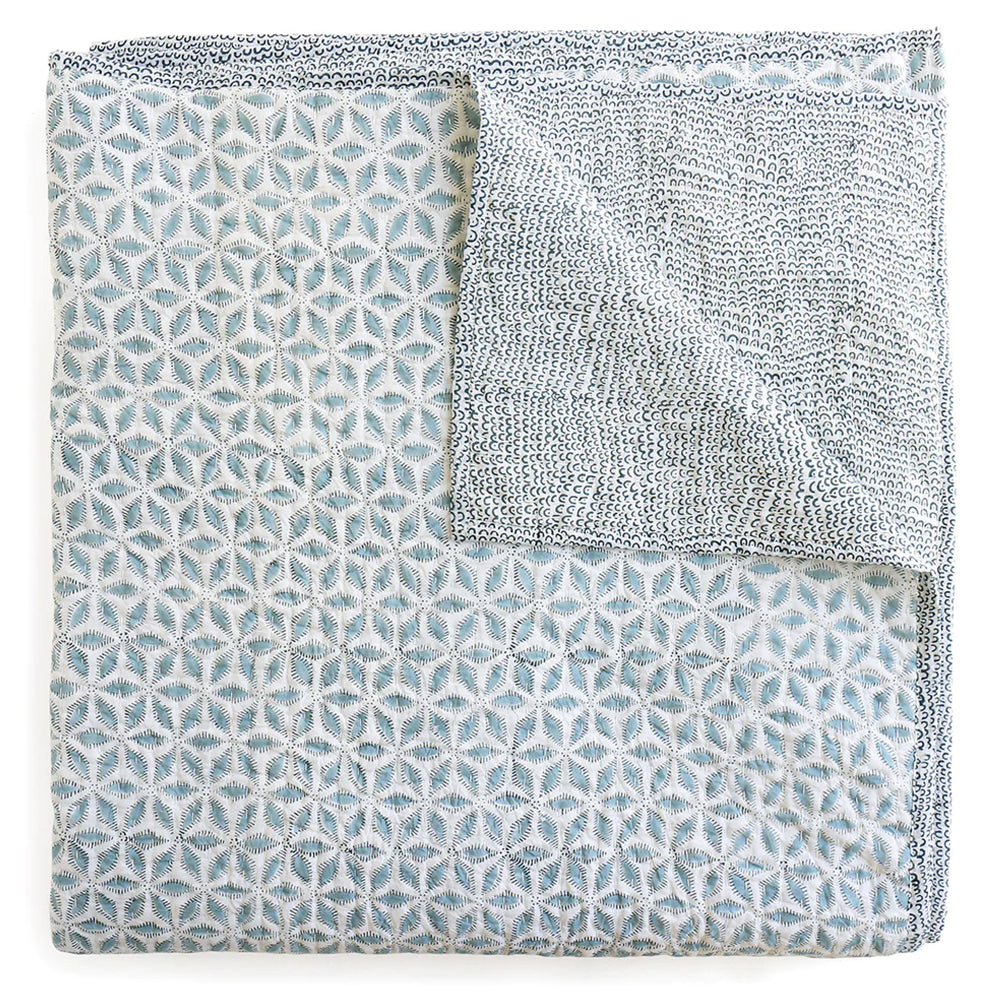 Walter G Hanami blue and white quilt. Shown folded with corner open to see the design on the reverse. 